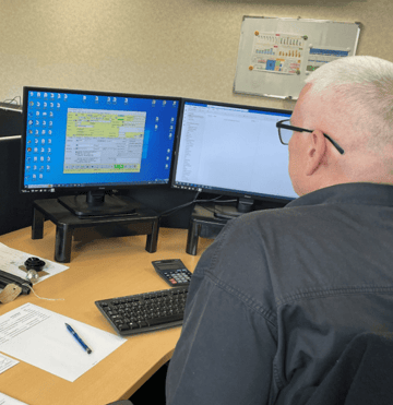 An employee looking on a pc for a customer to consider key factors of the RFQ stage